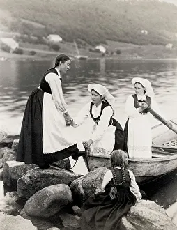 Norwegian woman traditional dress climbing out of boat