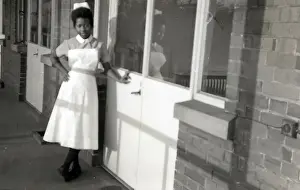 Student Prints: Nottingham. Student, Esmel May Woma in her nurses uniform leaning against the hospital