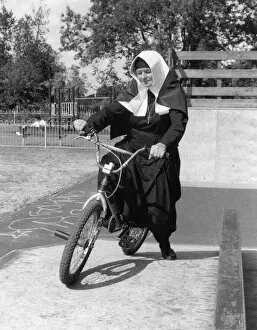Nun on a bicycle in a playground