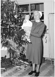 Images Dated 5th April 2017: Nurse holding child next to Christmas tree
