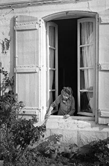 Images Dated 2nd July 2019: Old lady leans out of her house window - St Martin, France