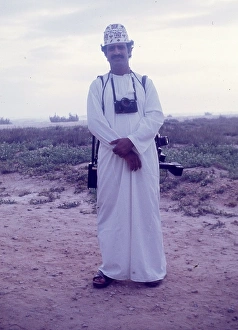 Images Dated 19th July 2016: Omani camera man stands on the beach in Salalah Oman