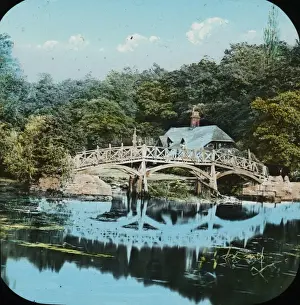Woodlands Prints: Ornate wooden bridge as seen from a large ornamental pond