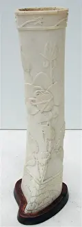 Pair of carved bone ornaments with raised foliate decoration