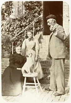Three people with a dog in a garden