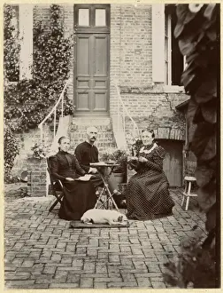 Three people with a dog in a garden