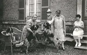 People with three dogs in a garden, France