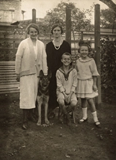 Alsatians Gallery: Four people with a German Shepherd dog in a garden