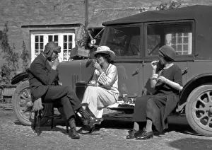 Picnicking Prints: Three people picnicking at the side of a car