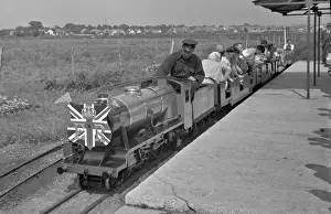 People riding on a miniature steam train