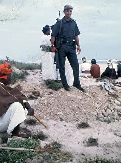 People standing and sitting on the beach in Oman