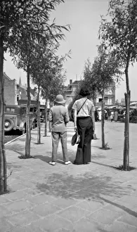 Sunny Prints: Two people walking along a tree-lined pavement