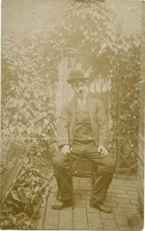 A person sitting in a back yard dressed up as Charlie Chaplin. Date: c.1918 A person sitting in a back yard dressed up as Charlie Chaplin. Date: c.1918