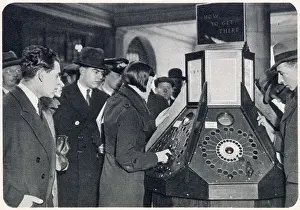 Customer Prints: Photograph showing a queue of passengers waiting to use the new mechanical informator at Charing Cross Underground