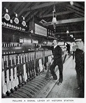 Levers Prints: Photograph showing the signalman in the act of pulling a signal lever to allow a train to enter one of the platforms