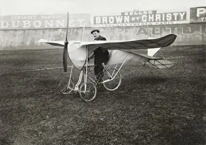Pilot Sitting on Bi-Cycle Aircraft with Adverts in the ?