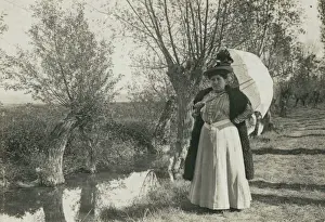 Plump woman with parasol by a stream