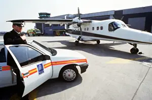 Paved Prints: Policeman, car and light aircraft
