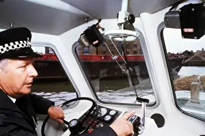 Policeman at the controls of a riverboat