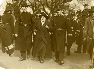 Policemen escorting a suffragette