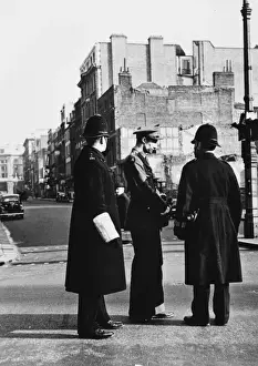 Two policemen on a war damaged street