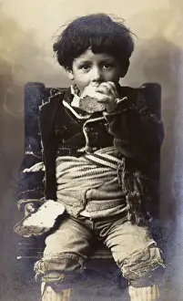 Tatty Prints: A poor young boy tucking into a hunk of bread - Italy