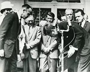 President John F. Kennedy stoops to retrieve the Nation?