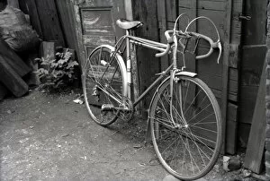 Suburban Collection: A Racing Bicyle leaned up against the fence in a back yard