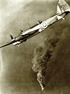 RAF bomber with German tanker on fire below, WW2
