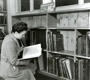 Bookshelves Prints: Reading a score in a music library