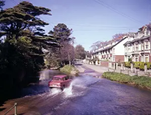 Flood Prints: Red car driving through water, Sidmouth, Devon