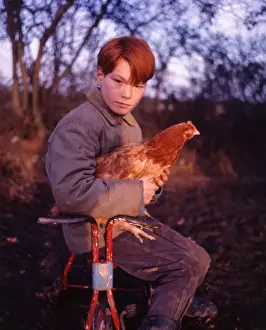 Red-haired gipsy boy with a chicken