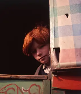 Red-haired gipsy boy looking out of his caravan