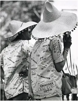 Afro Prints: Two revellers in matching party shirts and straw hats at the Port of Spain Carnival