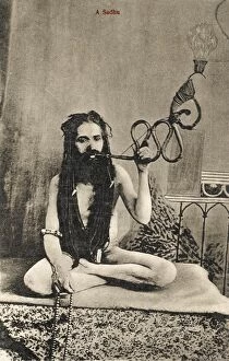 Ascetic Collection: A Sadhu smoking a remarkable pipe, India
