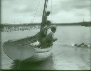 Sea Scouts swimming off the side of a dinghy