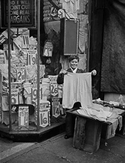 Shop assistant shows garments for inspection, London Shop assistant shows garments for inspection, London