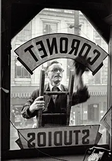 Haymarket Prints: Shot from inside Portrait studio of man cleaning studio window sign