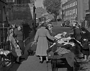 Sifting through old clothes at a market, London
