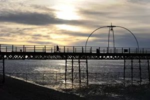 Contre Collection: Silhouette of boy running along Southport Pier at sunset