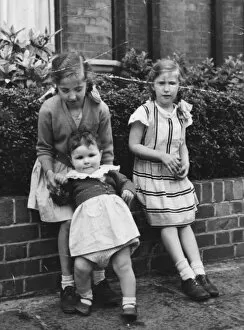 1950s Childhood Gallery: Three sisters sitting on a front garden wall