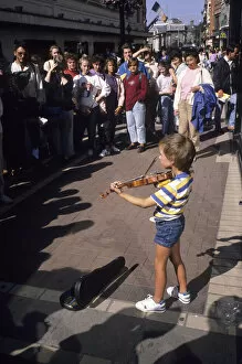 Images Dated 27th August 2019: Small boy busking with his violin for an audience in Dublin