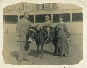 A small child goes for a donkey ride on the beach at an unidentified British seaside A small child goes for a donkey ride on the beach at an unidentified British seaside