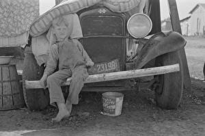 Son of white migrant sitting on bumper of their truck, Wesla Son of white migrant sitting on bumper of their truck, Wesla