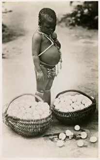 Baskets Collection: South Africa - a toddler looks down guiltily at broken eggs