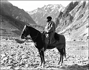 A Turkic man sat on a mighty steed in a mountain pass in the far north of India or the very south of Xinjiang Province, China on the road through the mountains to Kashgar. Photograph by Ralph Ponsonby Watts Southern China - Local Man on horseback