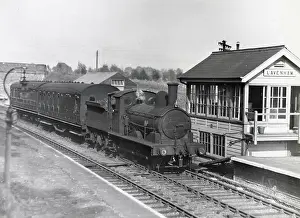 Steam locomotive and passenger carriages alongside a signal box near Lavenham, Suffolk. Date: circa 1960s