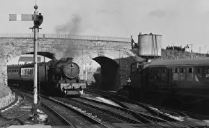 Steam locomotive passing under a bridge