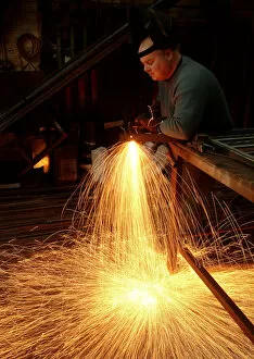 Images Dated 4th September 2019: A steelworker makes a shower of sparks in his workshop