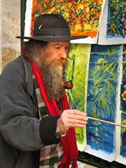 Smoker Gallery: A street artist, with a long beard smoking a large pipe